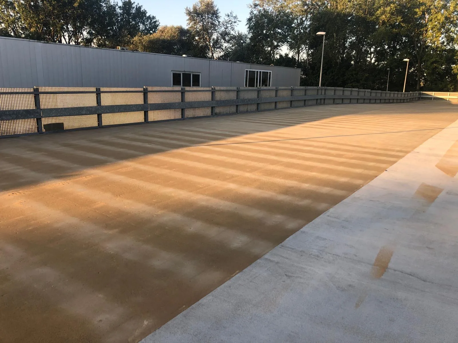 Comforpark Deck op een dakparkeerplaats met balustrade, gezien langs de lengte van het dek