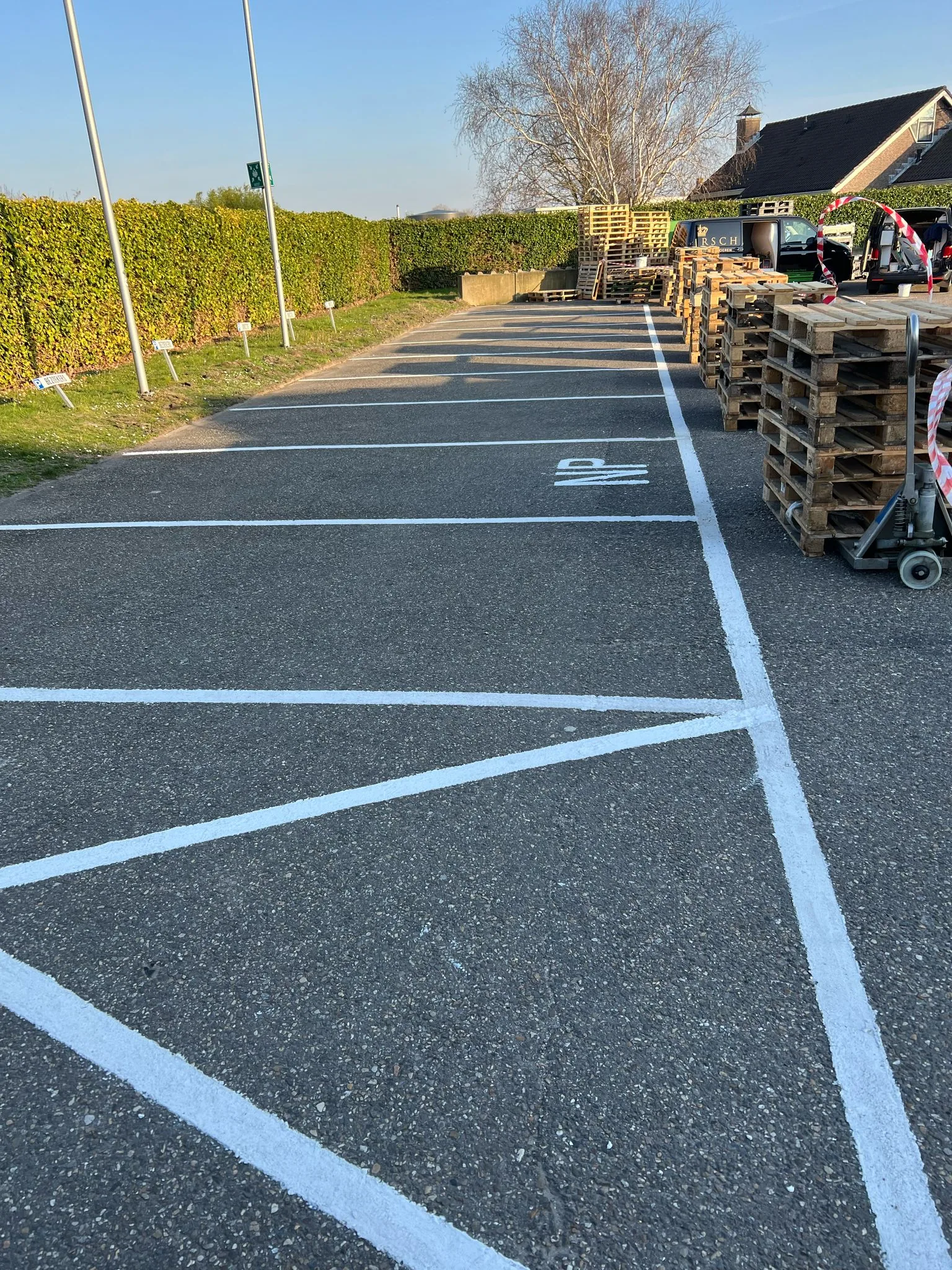 Antislip parkeercoating met witte vakbelijning op een buitenterrein bij een magazijn