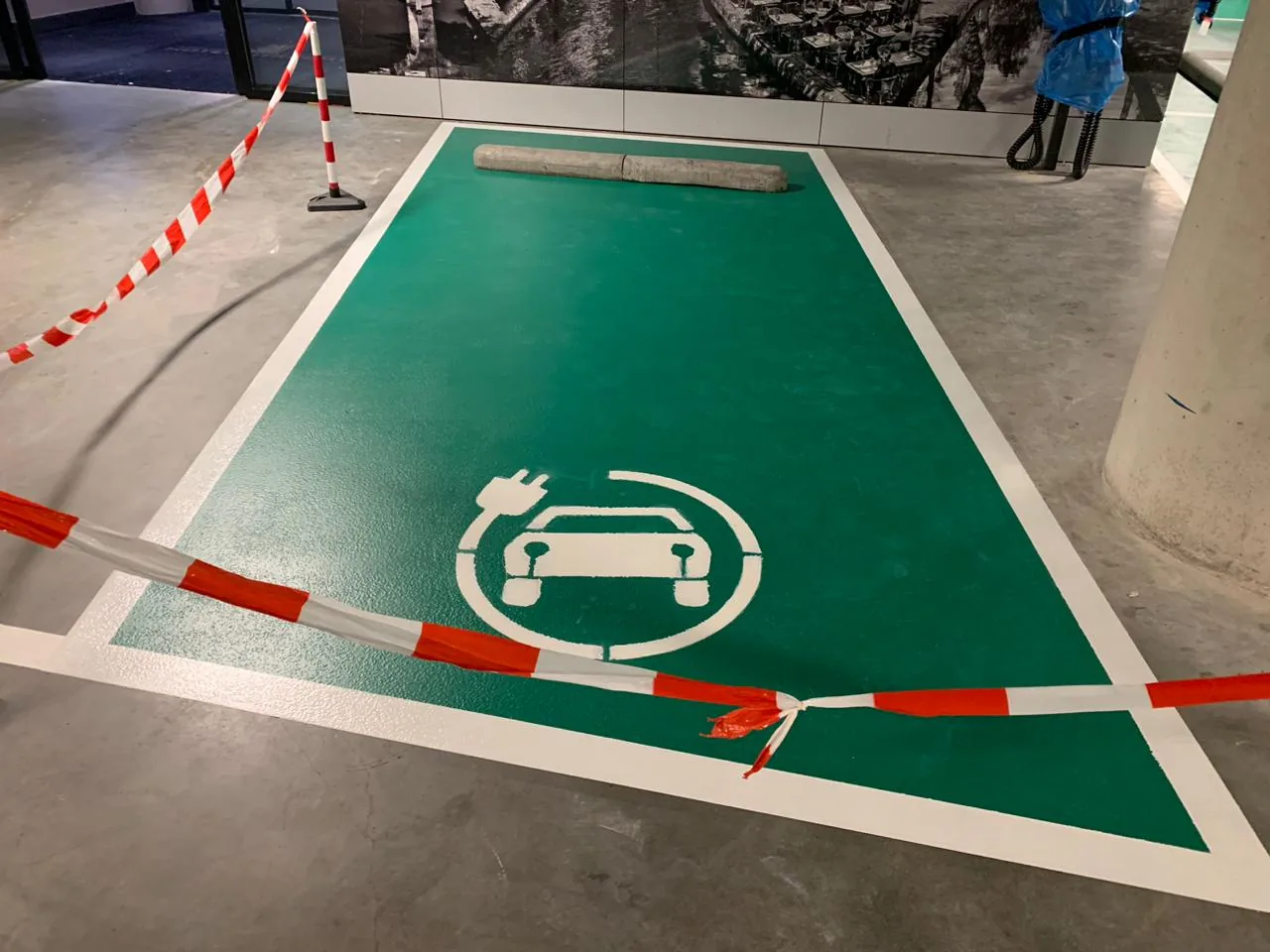 Groene Comforpark parkeervakken voor elektrisch laden met witte belijning en laadsymbool in een parkeergarage
