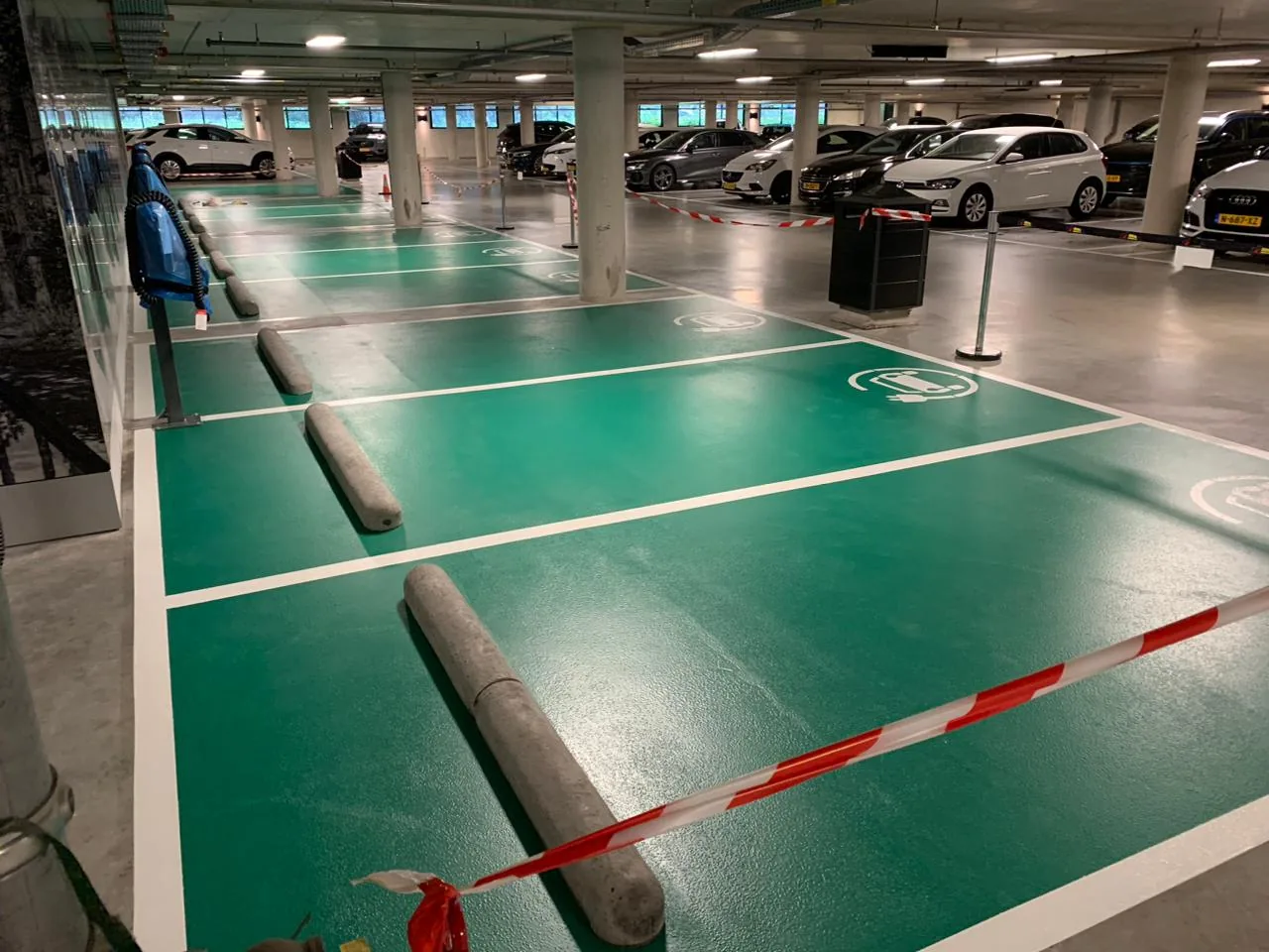 Groen gecoate laadvakken met witte markering in een ondergrondse parkeergarage
