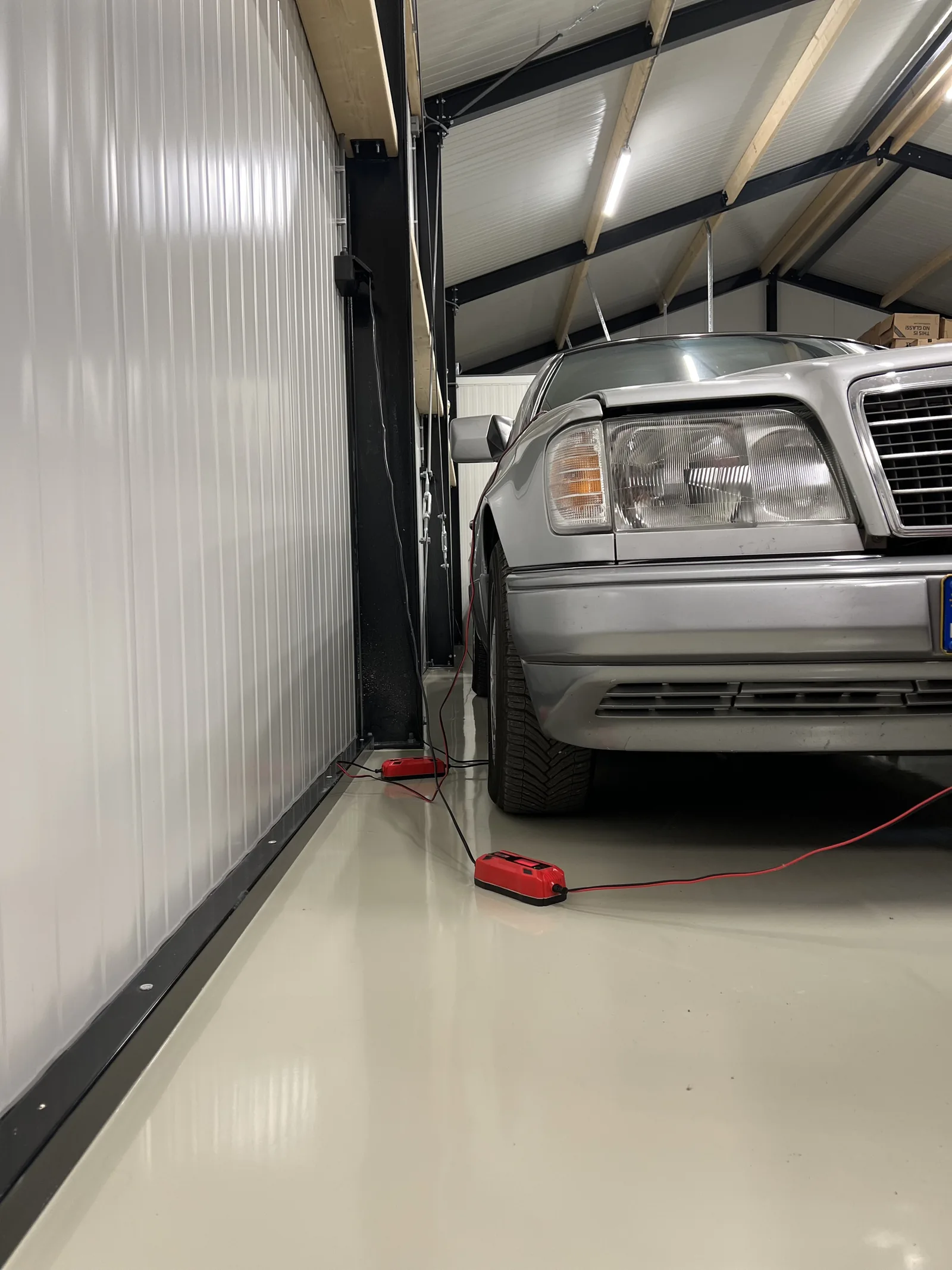 Grijze epoxy gietvloer onder een hefbrug in een privégarage