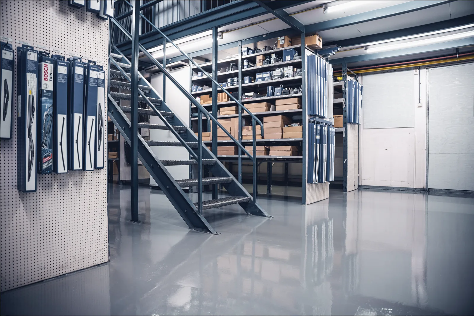 Epoxy coating op een entresolvloer met stalen trap en magazijnstellingen