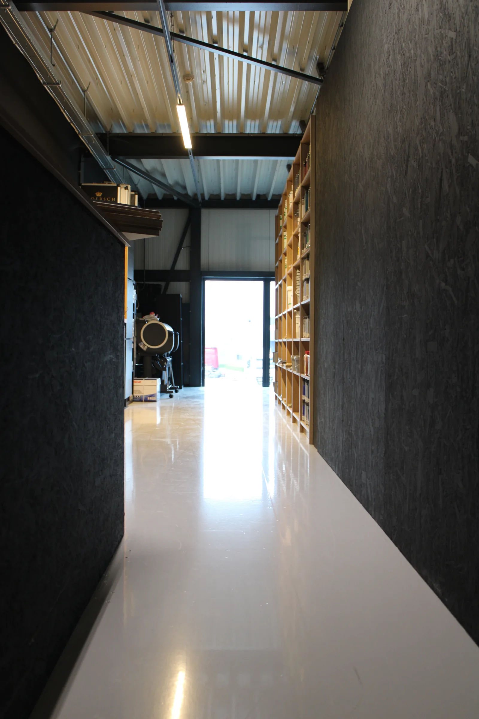 Epoxy coating in een werkplaats met houtopslag en daglicht door de opening