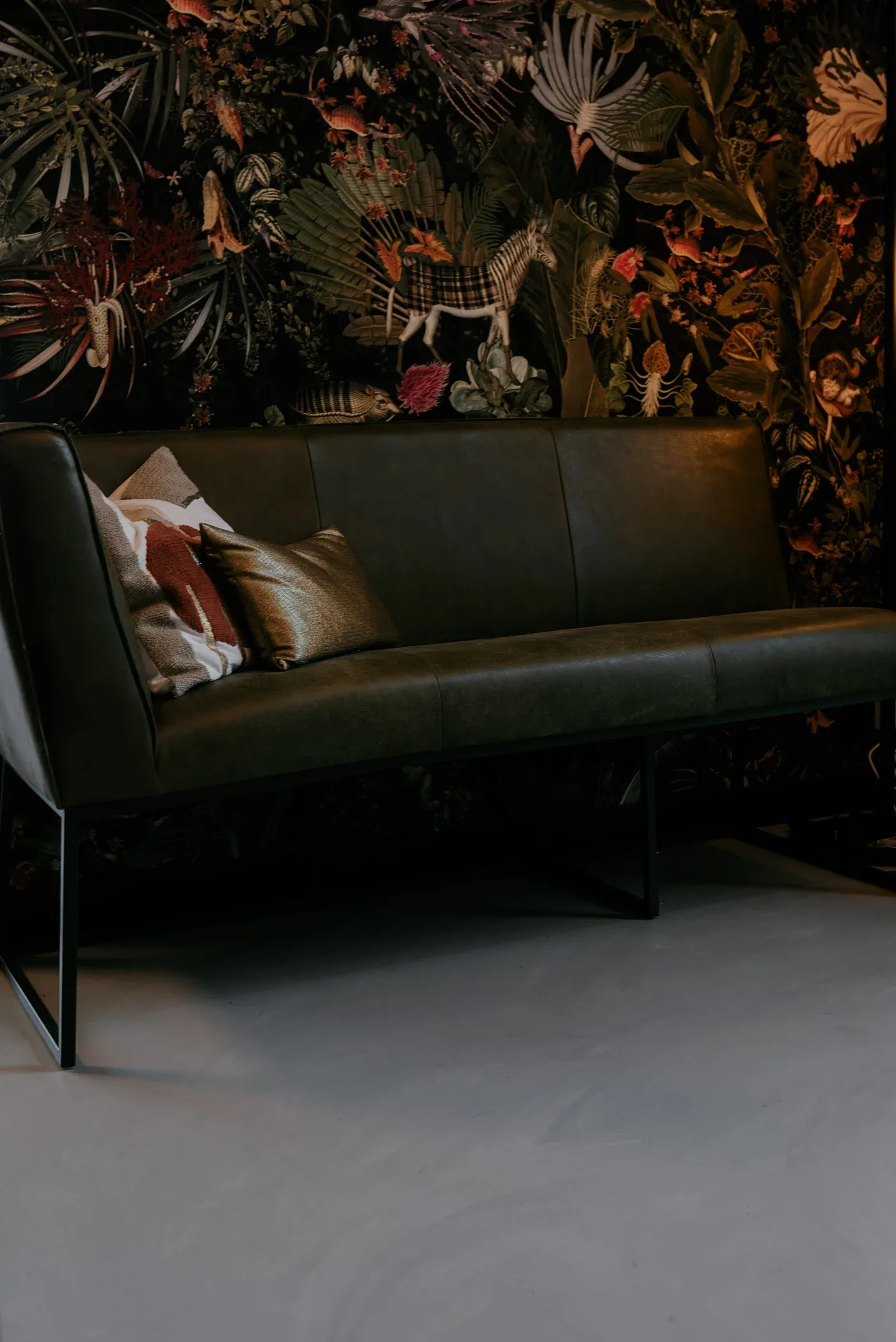 Comforpur 635 Betonlook gietvloer in een zithoek met leren bank tegen donker botanisch behang