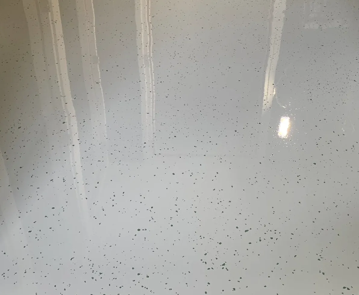 Close-up van Comforpur 670 Deco gietvloer in wit met fijne donkere vlokken