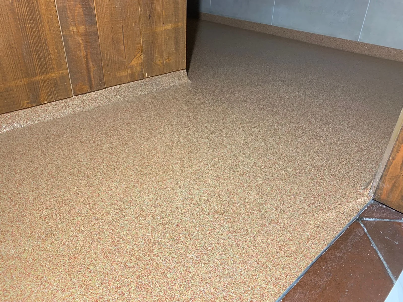 Beige QCF kwartsvloer met holplint bij een houten wand