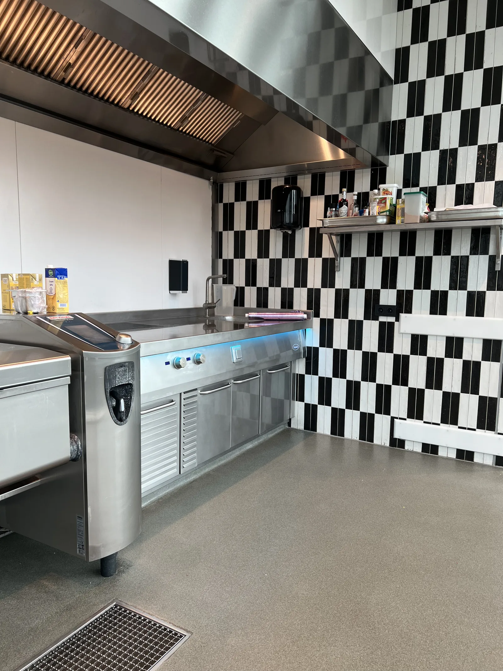 Kwartsvloer met afvoerput in een professionele keuken met kookeiland