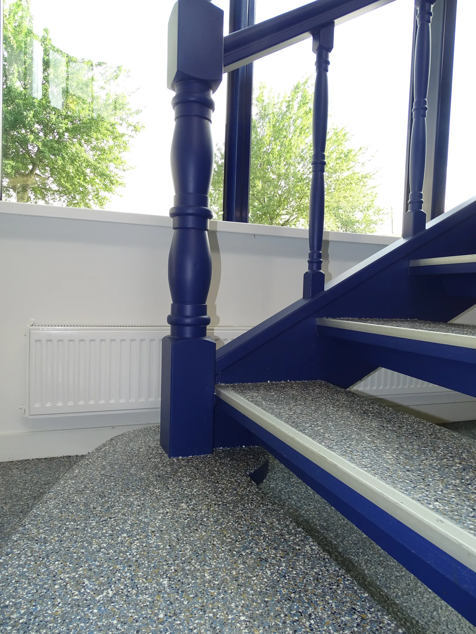 Comforpox Granito Flake vloer bij een blauwe trap