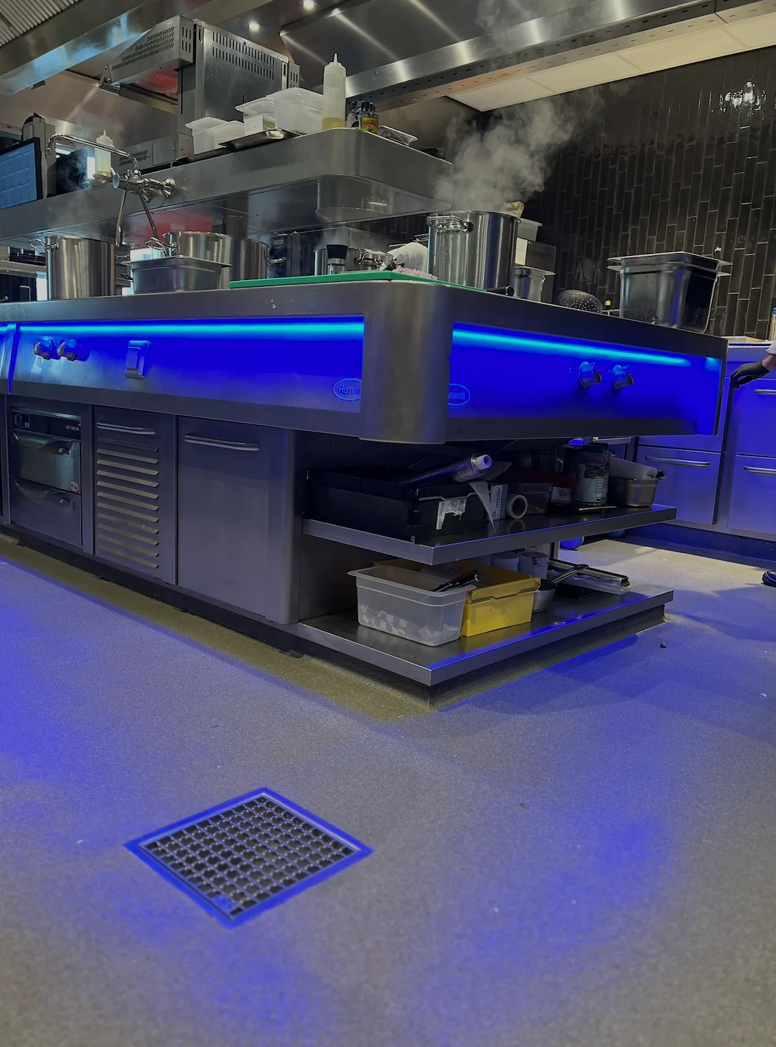 Antislip grootkeukenvloer met afvoerput onder blauw licht
