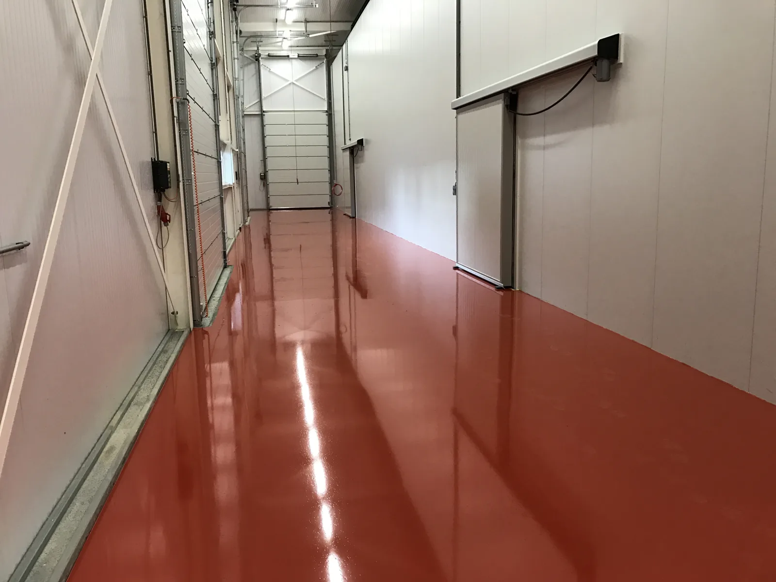 Rode Sika Ucrete vloer in een gang van een productiebedrijf