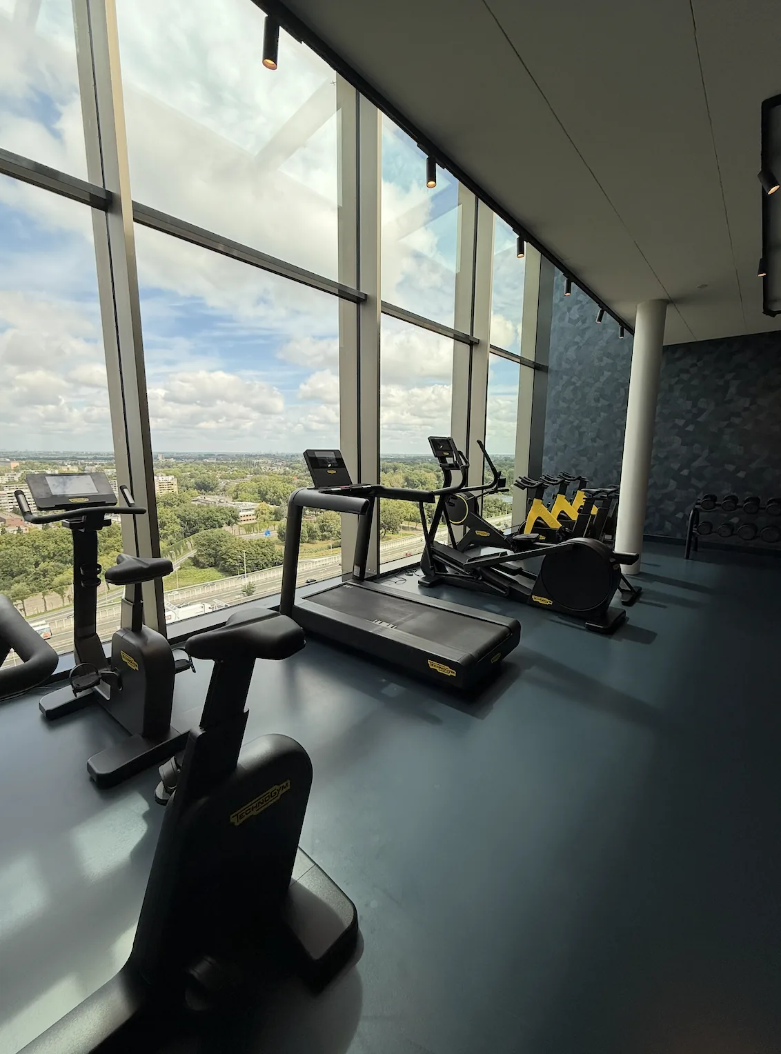 Fitnessruimte met donkere gietvloer en uitzicht bij Van der Valk Schiedam